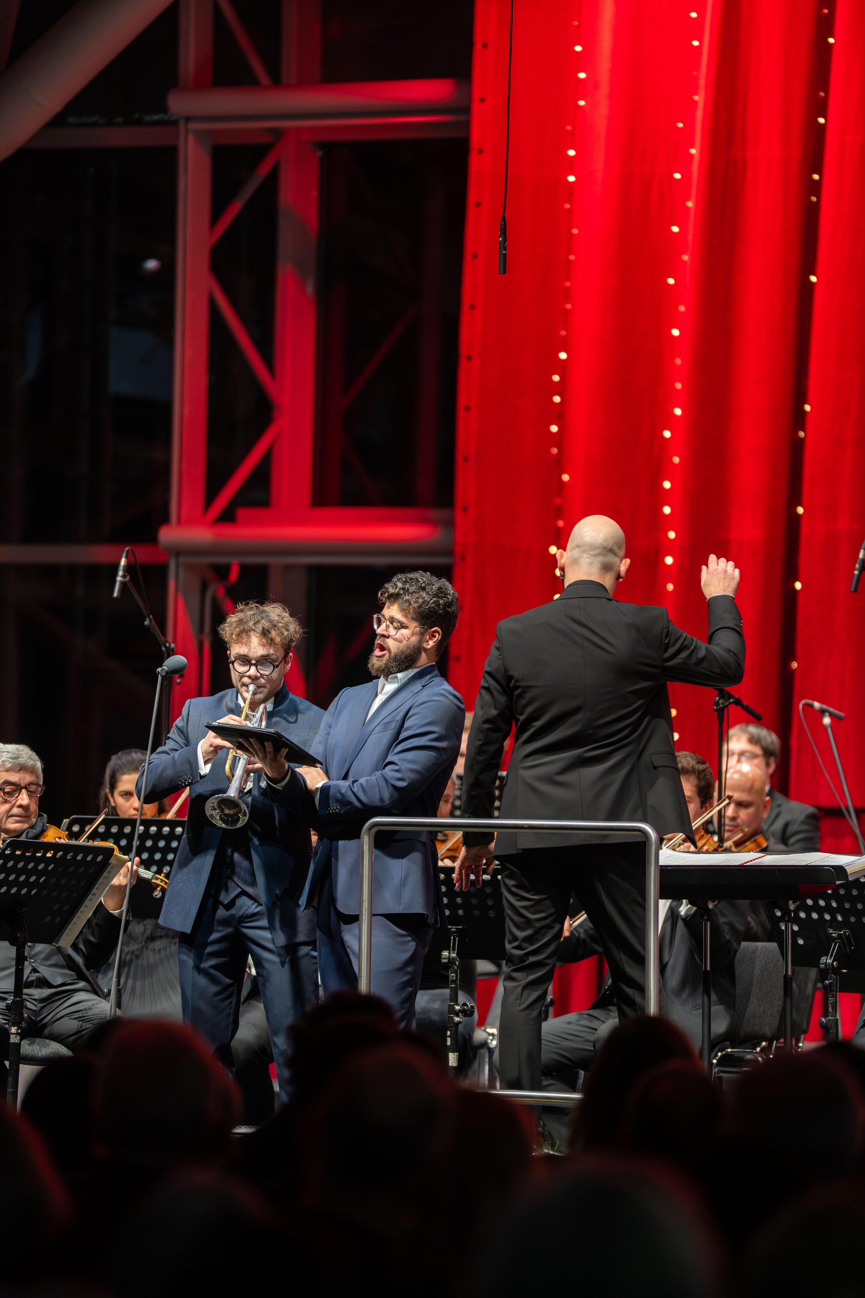 Audi Christmas Concert 2025 - Trumpeter Robin Paillet, vocalist Lukas Enoch Lemcke (bass) and conductor Ariel Zuckermann (from left) on stage at the Audi Christmas Concert 2025