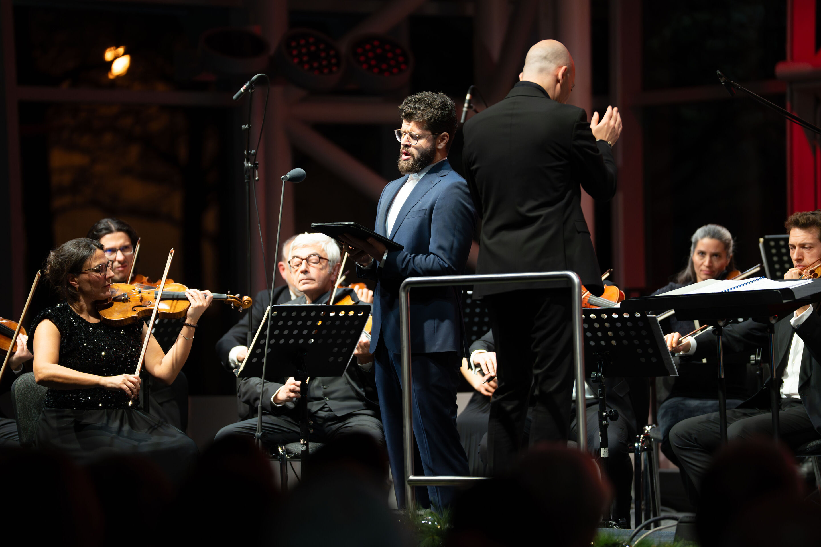 Audi Christmas Concert 2025 - Vocalist Lukas Enoch Lemcke (bass) and the Ingolstadt Chamber Philharmonic, conducted by Ariel Zuckermann, on stage at the Audi Christmas Concert 2025