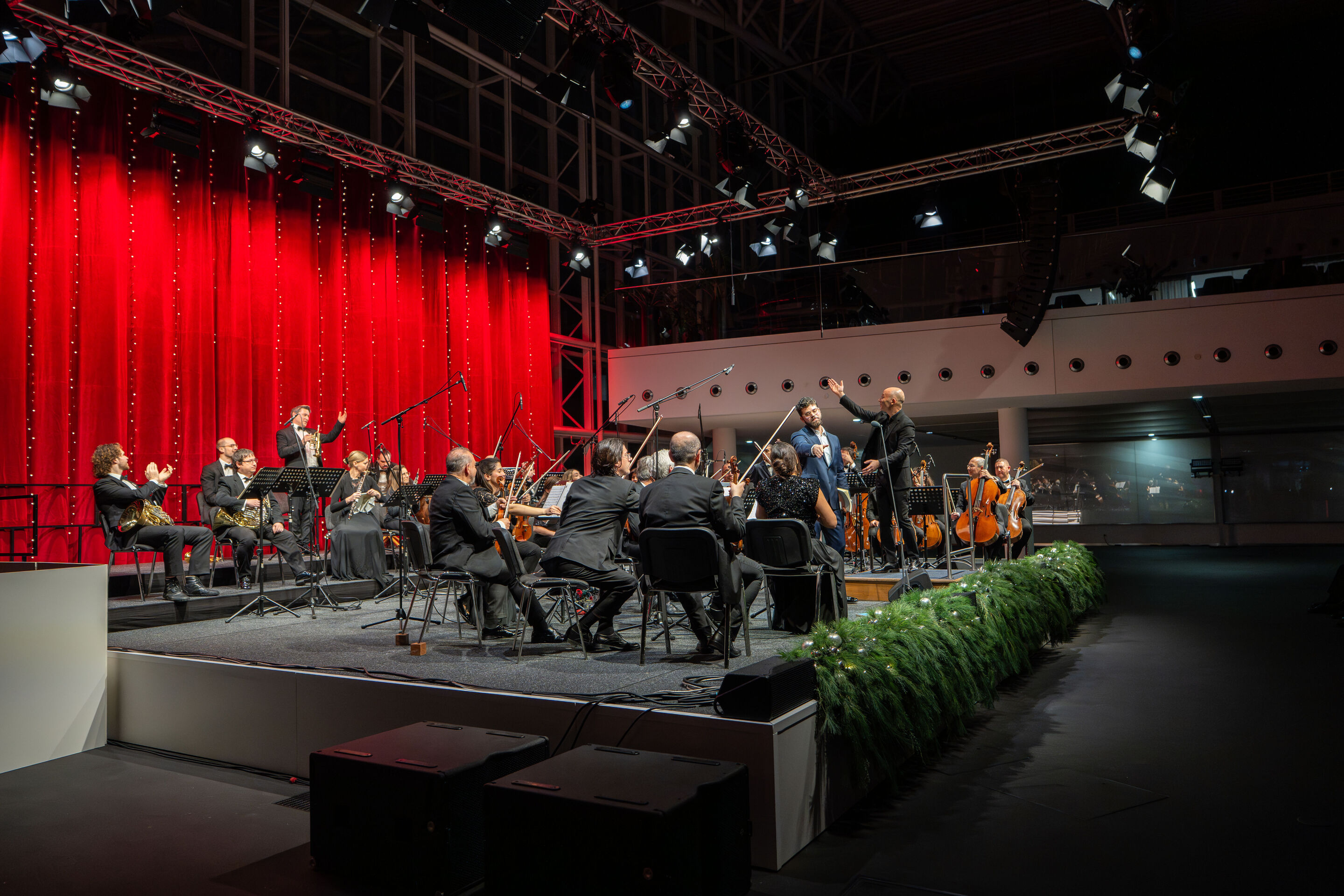 Audi Christmas Concert 2025 - Vocalist Lukas Enoch Lemcke (bass) and the Ingolstadt Chamber Philharmonic, conducted by Ariel Zuckermann, on stage at the Audi Christmas Concert 2025