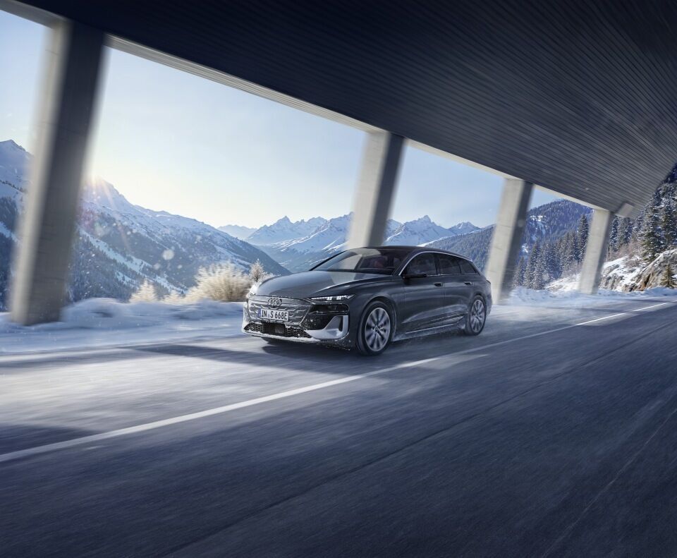 Audi S6 Avant e-tron - An Audi S6 e-tron driving through a gallery against a snowy mointain backdrop.